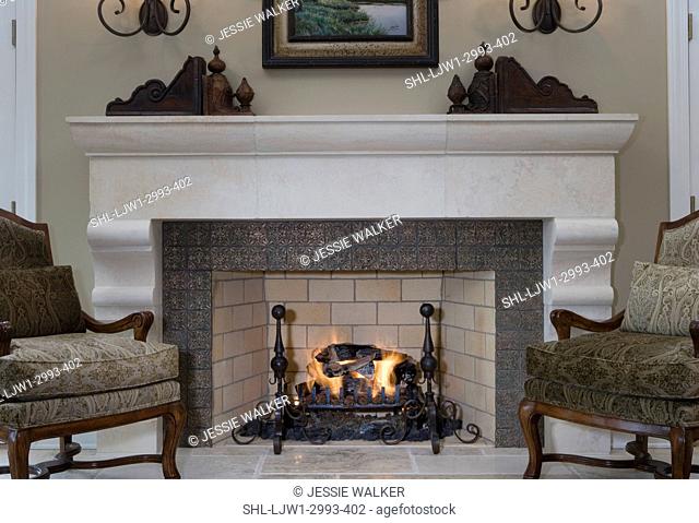 FIREPLACES:, limestone fireplace with bronze tile, sage green paisley bergere chairs, architectural accents on mantel