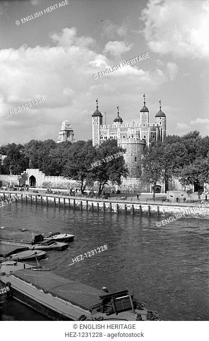 The Tower of London from Tower Bridge, London, c1945-c1965. The White Tower, the massive Norman keep, dominates. In the foreground are Thames barges