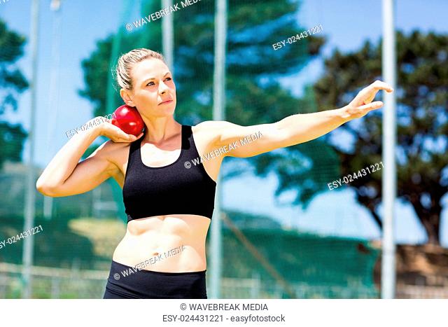 Female athlete preparing to throw shot put ball