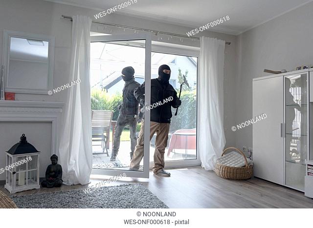 Two burglars entering an one-family house at daytime