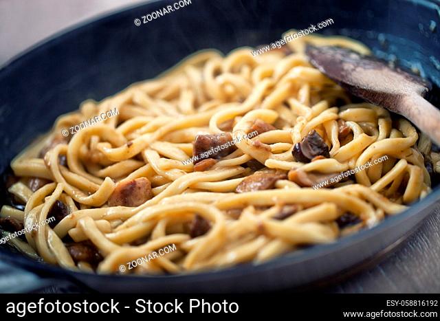 Cooking Fresh Tagliatelle with mushrooms in a Pan. High quality photo