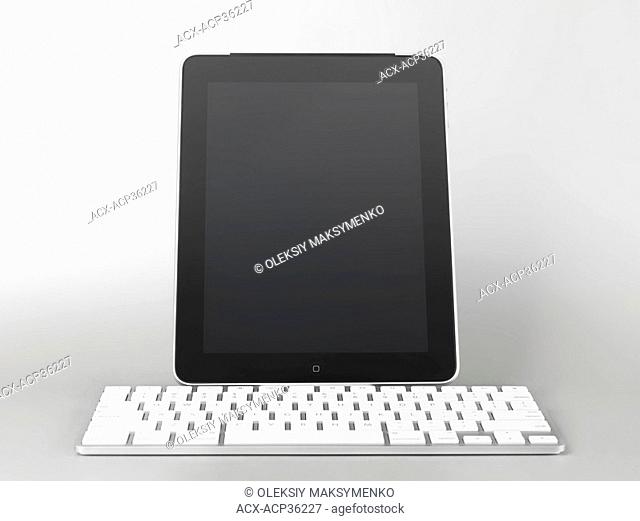 Apple iPad 3G tablet computer with a keyboard dock accessory isolated on gray background