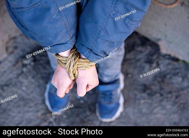 Bound hands of a child. Photo on the theme of child abuse, kidnapping and adult cruelty issues
