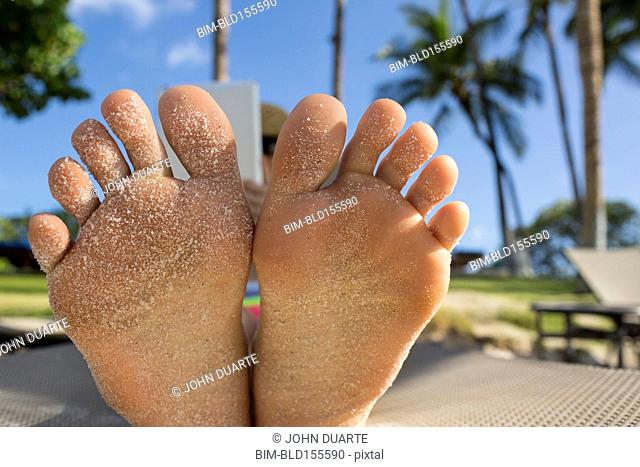 Close up of bottom of sandy feet of Caucasian woman