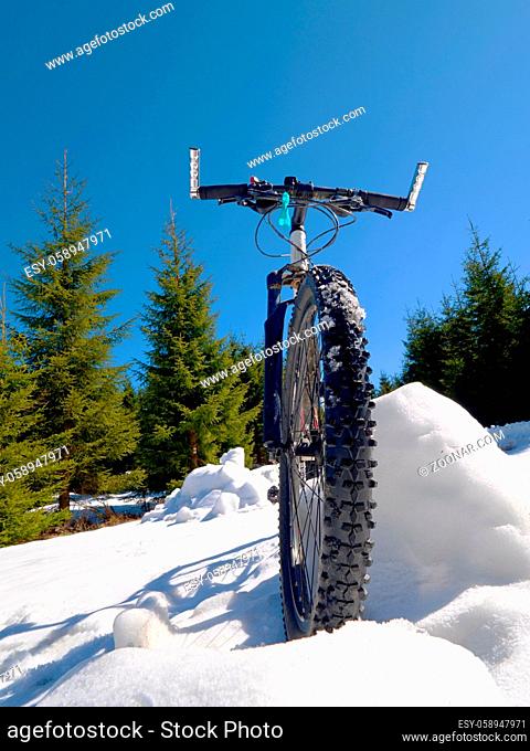 Wide view photo of mountain bike in deep snow. Winter mountains with road lost under snow