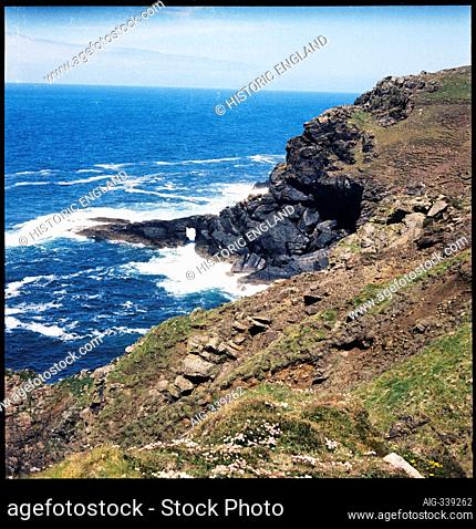 The cliffs at Carn Vellan and waves crashing around the natural arch in the distance, Carn Vellan, St. Just, Cornwall, UK