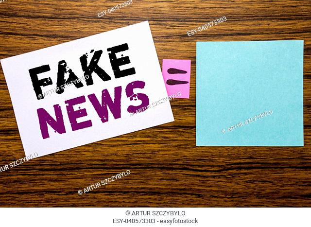 Handwriting Announcement text showing Fake News. Business concept for Hoax Journalism written on sticky note paper wooden background