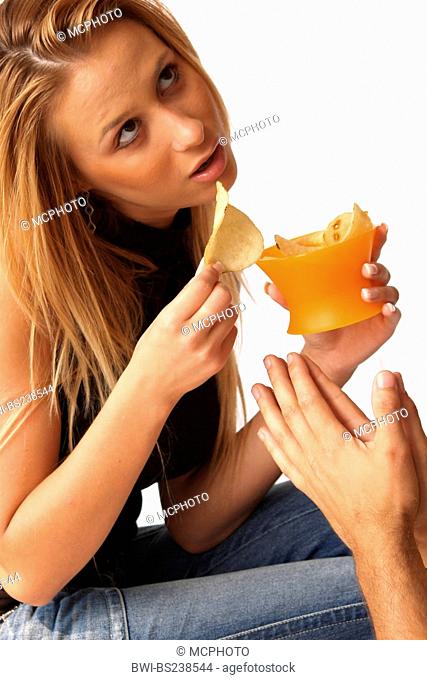 man begging potatoe chips from his blond young woman with his hands folded