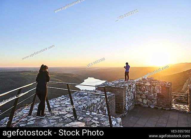 Young couple visiting Monfragüe Castle during sunset, Extremadura (Spain)