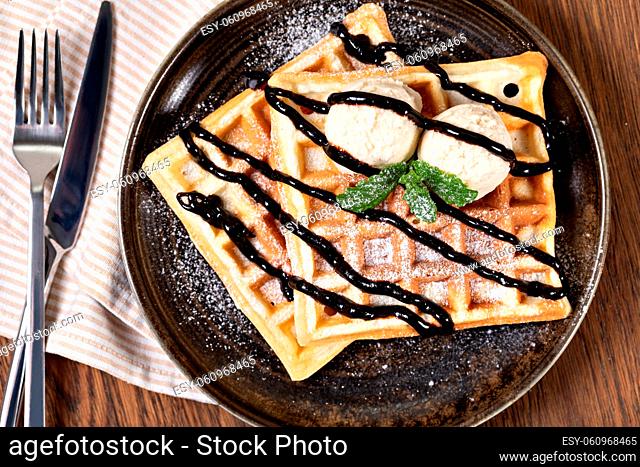 viennese waffles with chocolate syrup on a wooden