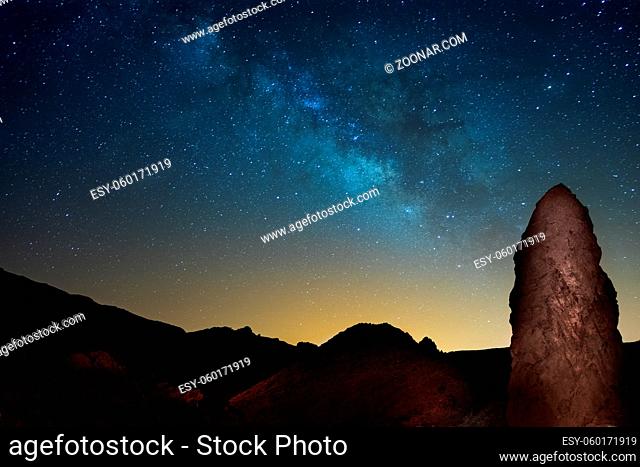 The night sky and Milky Way. The rock Roques de Garcia on the foreground. Tenerife, Canary islands. Spain