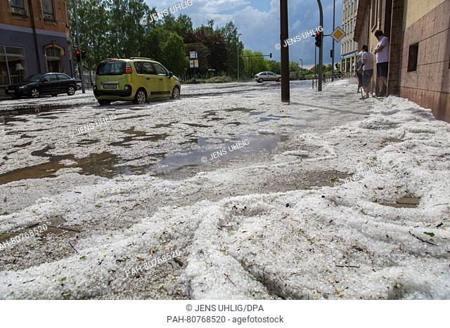 Hailstones lie on a street after a heavy storm in Chemnitz, Germany, 28 May 2016. Photo: JENS UHLIG/dpa | usage worldwide. - Chemnitz/Saxony/Germany