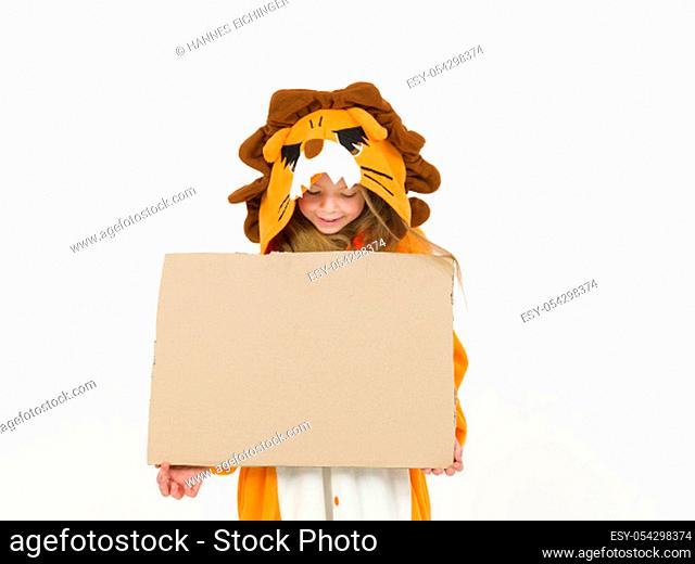 pretty blonde girl with cozy lion costume is holding a brown sign with nothing written on it in front of white wall