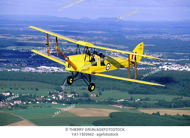 Old British trainer biplane De Havilland DH-82a Tiger Moth in flight over France