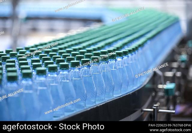 22 June 2022, Saxony, Lichtenau: Bottles of ""medium"" mineral water pass through the filling line of Lichtenauer Mineralquellen GmbH
