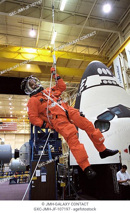Astronaut Robert L. Curbeam, Jr., STS-116 mission specialist, uses the Sky-genie to lower himself from a simulated trouble-plagued shuttle in a training session...