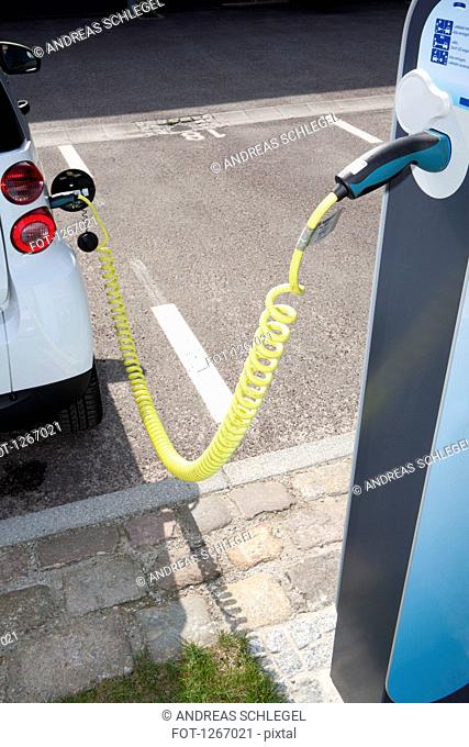 An electric car recharging at a charging station