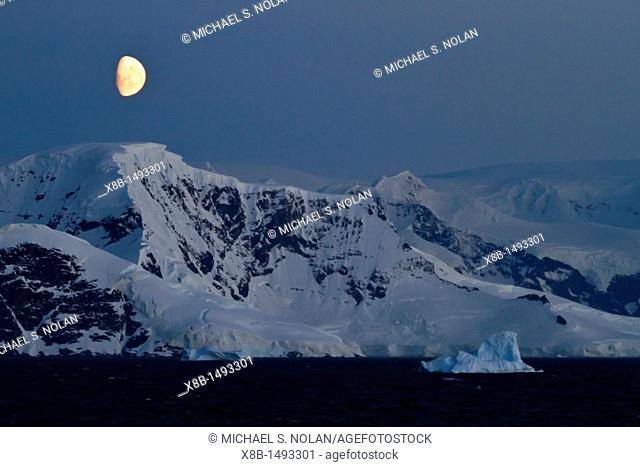 View of the moon rising over snow-covered mountains on the Antarctic Peninsula, Antarctica MORE INFO Lindblad Expeditions pioneered non-scientific travel to...