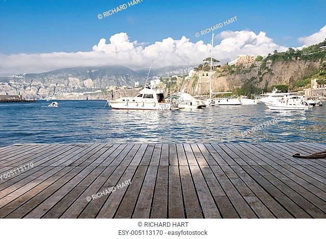 boats at end of wooden pier sorrento italy