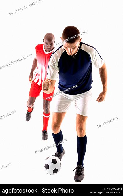 Full length of young male multiracial competitors playing soccer against white background