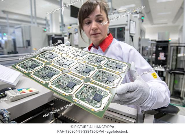 02 March 2018, Germany, Ingolstadt: A worker checking the production of circuit boards for radar sensors at Continental factory