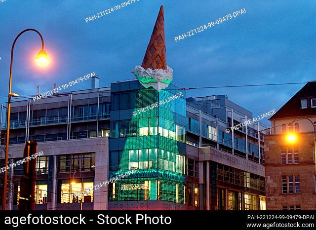 24 December 2022, North Rhine-Westphalia, Cologne: The ice cream cone by artist Claes Oldenburg on the Neumarktgalerie, together with the lighting of the...