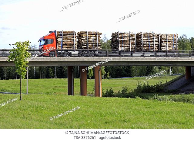 Turku, Finland. August 24, 2019. Orange Scania R730 XT truck pulls logging trailer on a highway bridge on a sunny day. Scania in Finland 70 years tour