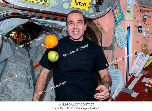 NASA astronaut Rick Mastracchio, Expedition 38 flight engineer, is pictured near fresh fruit floating freely in the Unity node of the International Space...