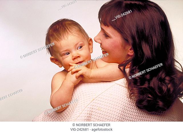portrait, indoor, close-up, woman with long brown hair wearing a white morning gown with her 6-month-old naked baby on her srm  - GERMANY, 15/03/2005