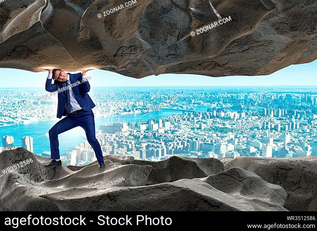Businessman supporting stone under pressure