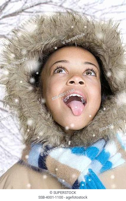 Girl trying to catch snowflakes on her tongue