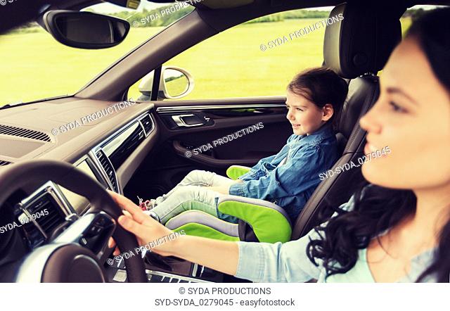 happy woman with little girl driving in car