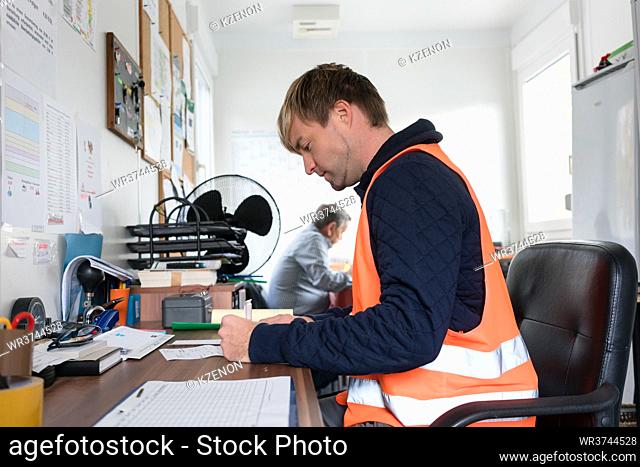 Worker in office of recycling center with papers