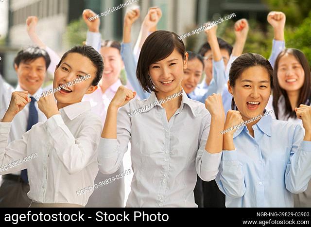 Portrait of group of business people cheering with fists up
