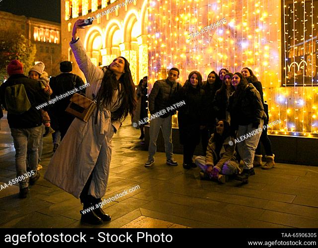 ARMENIA, YEREVAN - DECEMBER 19, 2023: People take pictures during a ceremony to light up Yerevan's main Christmas tree in Republic Square