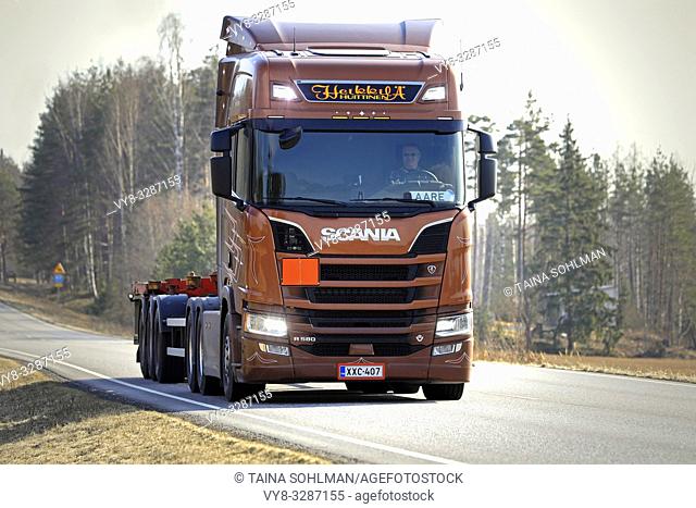 Salo, Finland - April 5, 2019: Bronze Next Generation Scania R580 truck of AH Trans Oy for chemical container transport on road, high beams briefly on