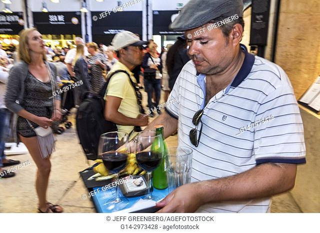 Portugal, Lisbon, Cais do Sodre, Mercado Da Ribeira, Time Out Market, market hall, food court, dining, tables, crowded, busy, man, carrying food tray, Hispanic