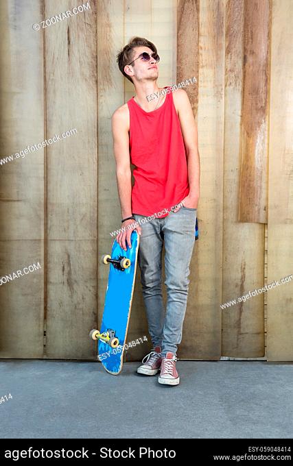 Portrait of young fashion guy with a skateboard
