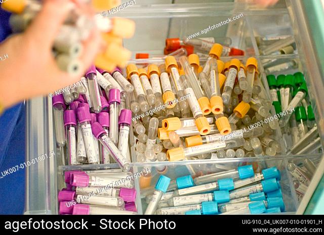 A drawer containing transparent plastic containers with multi-coloured coded caps used to store blood and waste kidney fluids in the renal dialysis department...