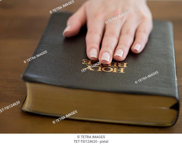 Woman's hand on Bible