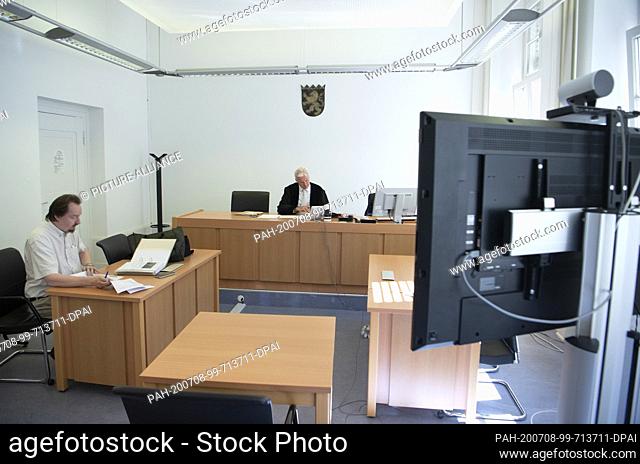 26 June 2020, Hessen, Frankfurt/Main: A lawyer is connected to a video monitor during a hearing at the local court in Frankfurt am Main