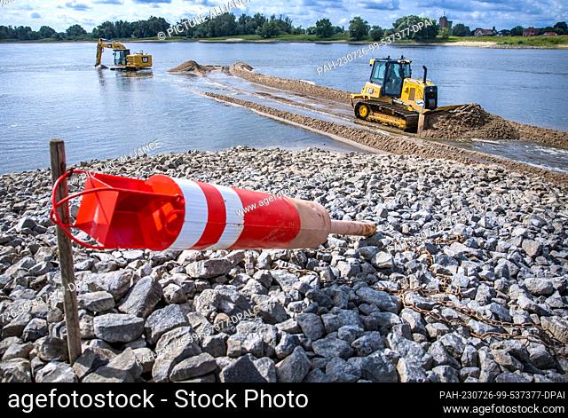 26 July 2023, Lower Saxony, Neu Bleckede: Excavators and bulldozers are used to deepen the access road to the Elbe ferry pier