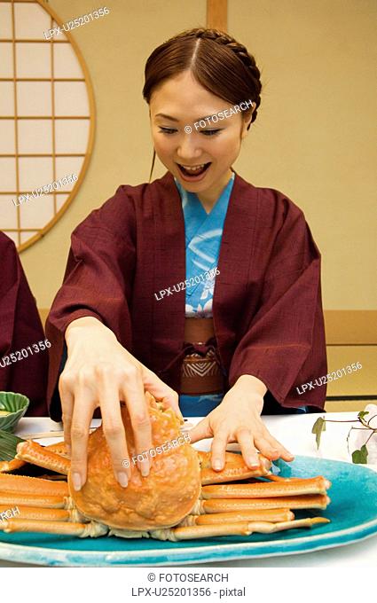 Woman in yukatas eating seafood