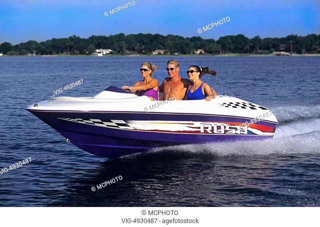 Couples running motor boat with wake and excitement as it moves thru water with speed - 01/01/2014