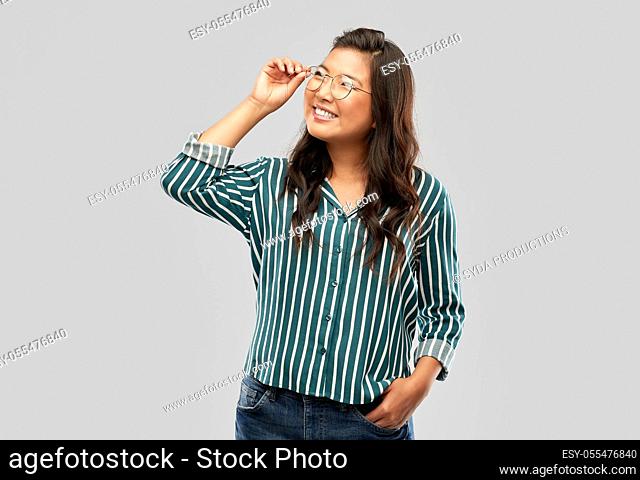 happy asian woman in glasses or student