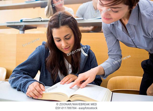 Teacher and student looking at a book