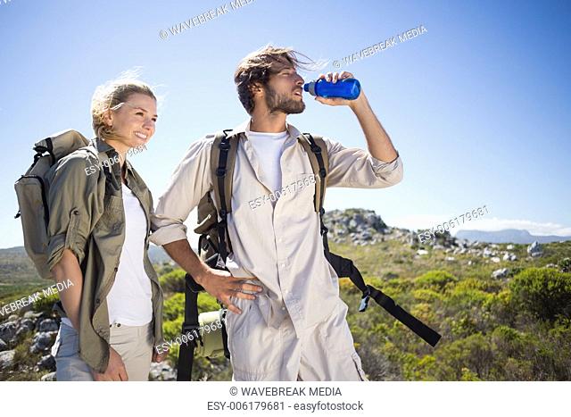 Hiking couple standing on mountain terrain taking a break