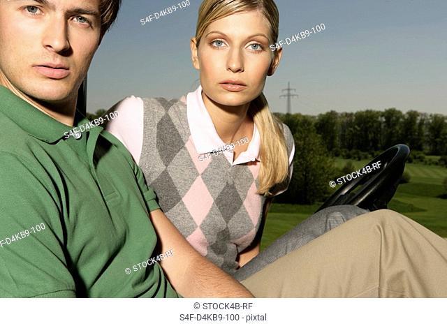 Young couple in golf cart