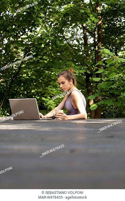 ragazza al computer in giardino