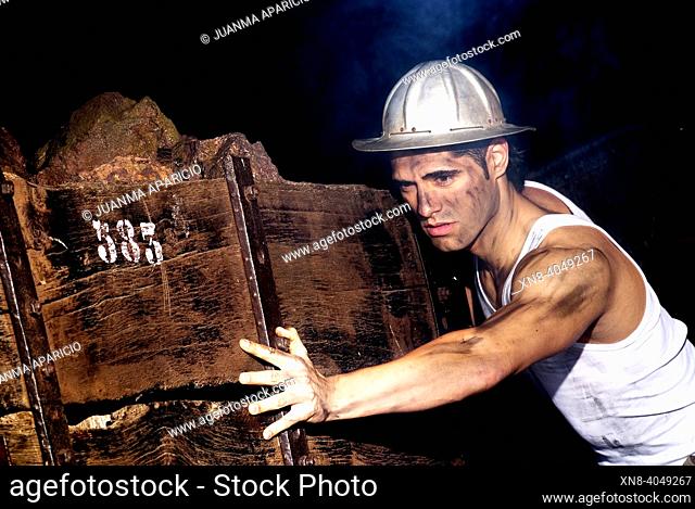 Representation of a miner pushing bagonetas iron ore within the mine